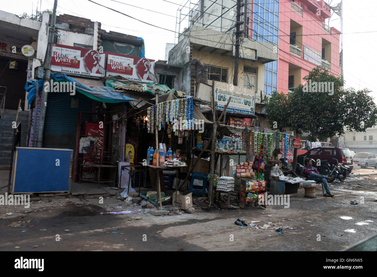 Una serie di negozi e bancarelle in una zona impoverita di Agra a Uttar Pradesh. India il cartello turistico per il Taj Mahal sul Foto Stock