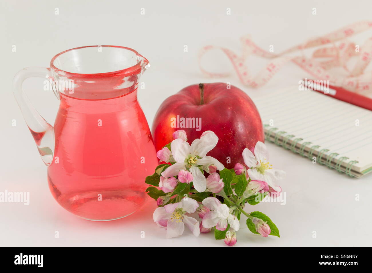 Red apple e aceto di mele decorata con fiori Foto Stock