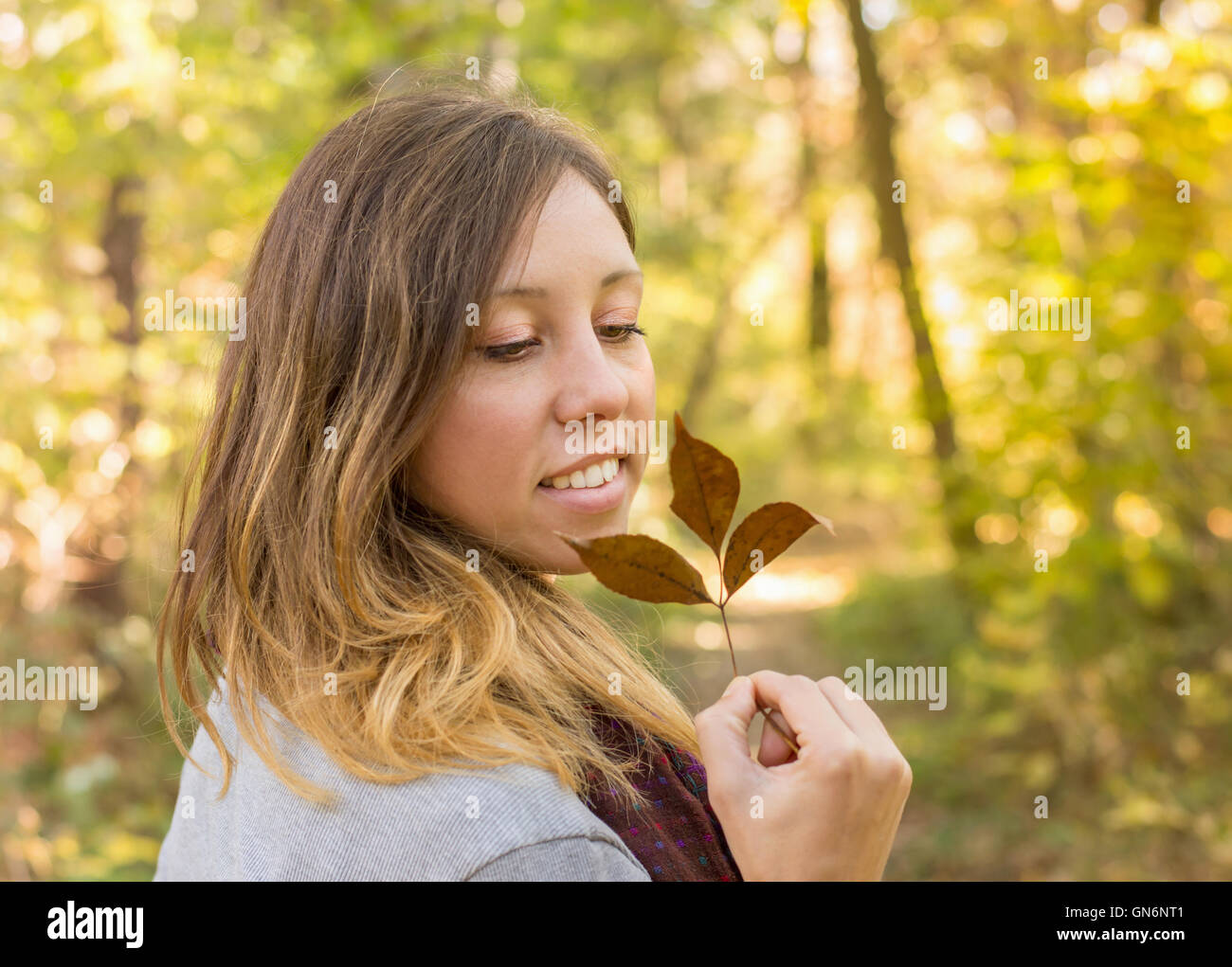 Donna felice holding autumn leaf nel parco Foto Stock