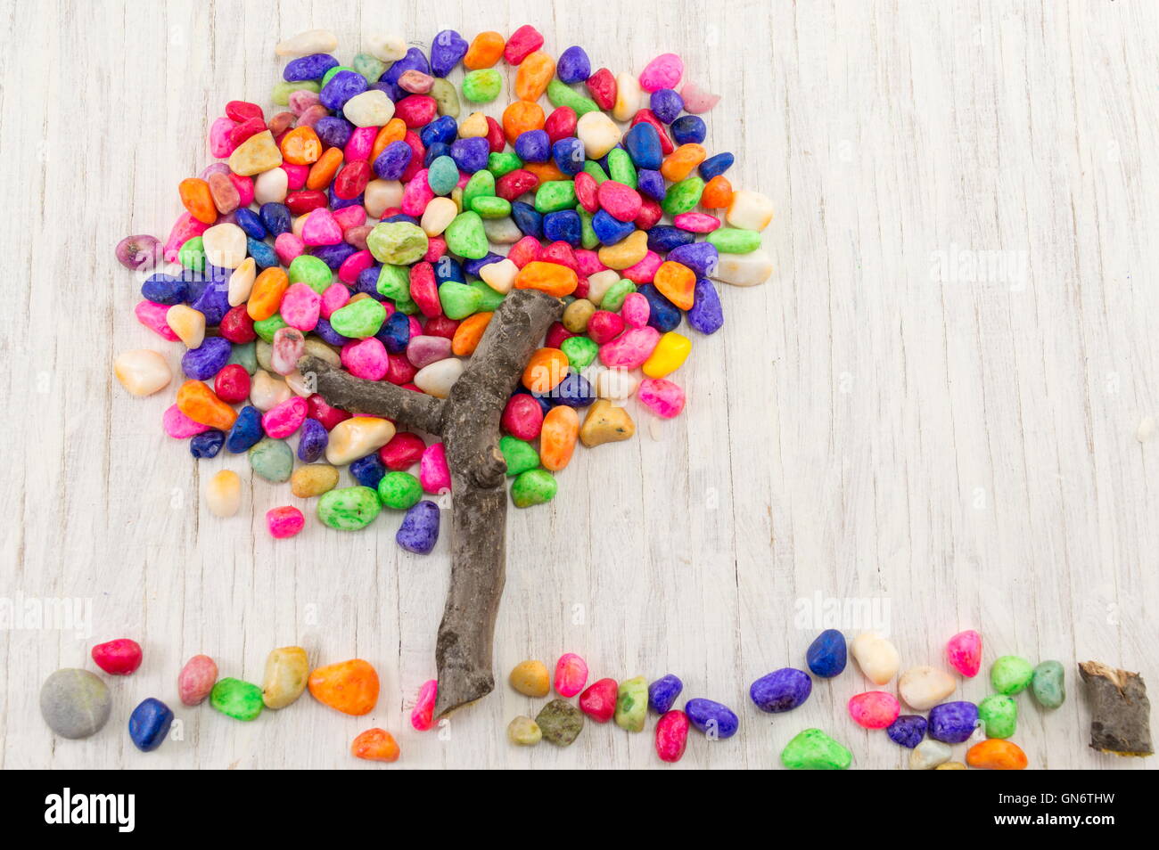 Rocce colorate formando una forma ad albero sul tavolo di legno Foto Stock