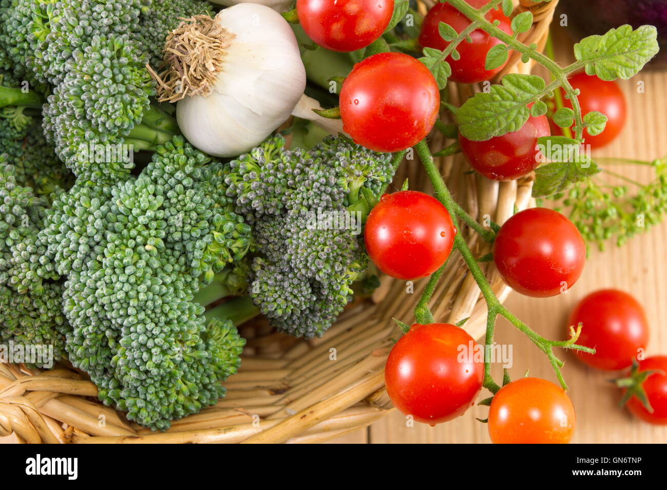 Broccoli di pomodoro e cipolle in un recipiente di vimini Foto Stock