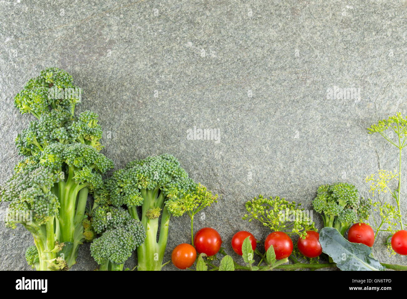 Sani e freschi di broccoli e pomodoro sul tavolo di pietra Foto Stock