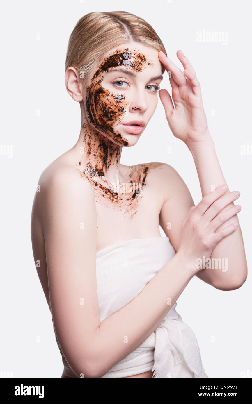 Peeling viso con la macchia di caffè,bellissima giovane donna trattamento del viso per la pulizia della pelle e peeling. esfoliazione del vecchio delle cellule della pelle e ringiovanimento. Foto Stock