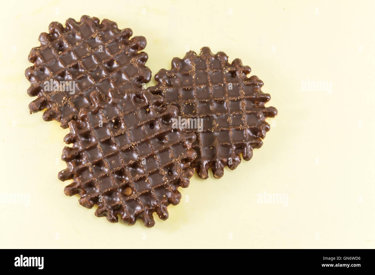 Ricoperta di cioccolato round biscotti fatti in casa su sfondo giallo Foto Stock
