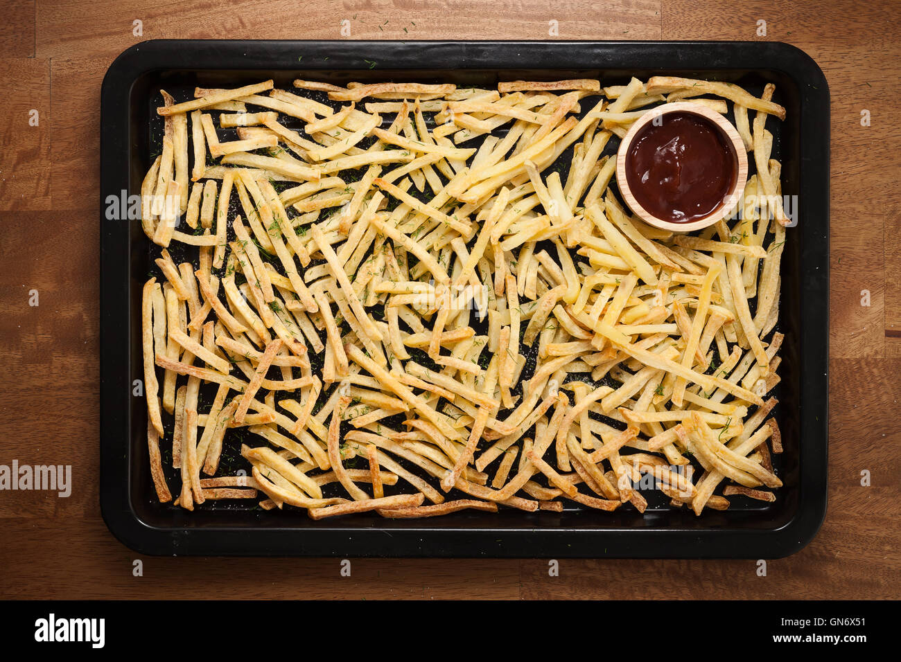 Fries ketchup francese ancora vita piatta aneto laici sale alle erbe aromatiche junk un fast food Sfondo legno Foto Stock