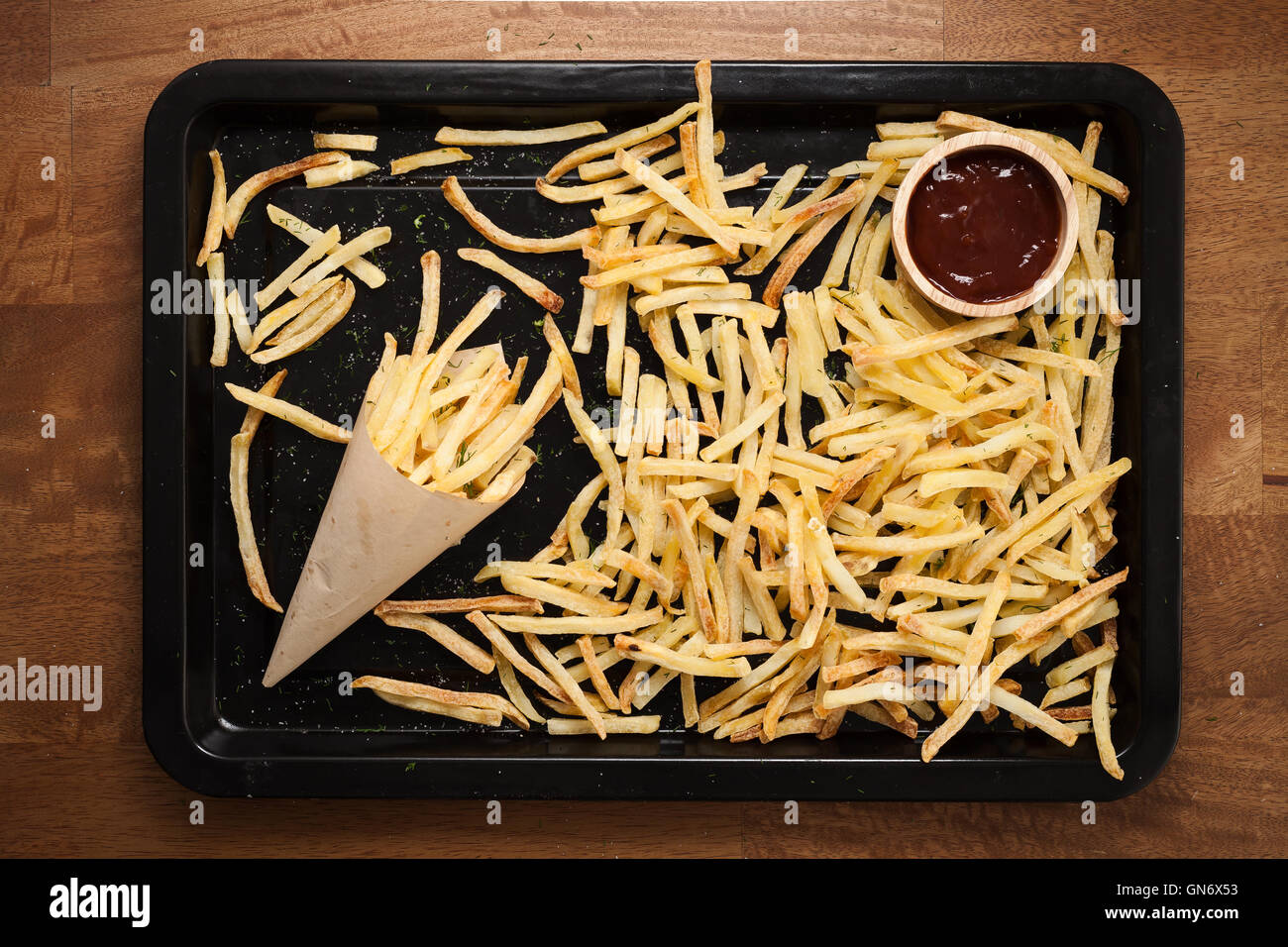 Fries ketchup francese ancora vita piatta aneto laici sale alle erbe aromatiche junk un fast food Sfondo legno Foto Stock