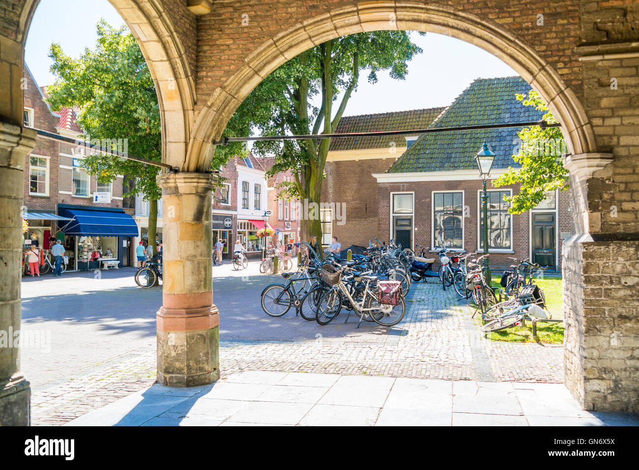 Biciclette e persone shopping in Koorstraat da arcate di ingresso della chiesa di San Lorenzo a Alkmaar, North Holland, Paesi Bassi Foto Stock