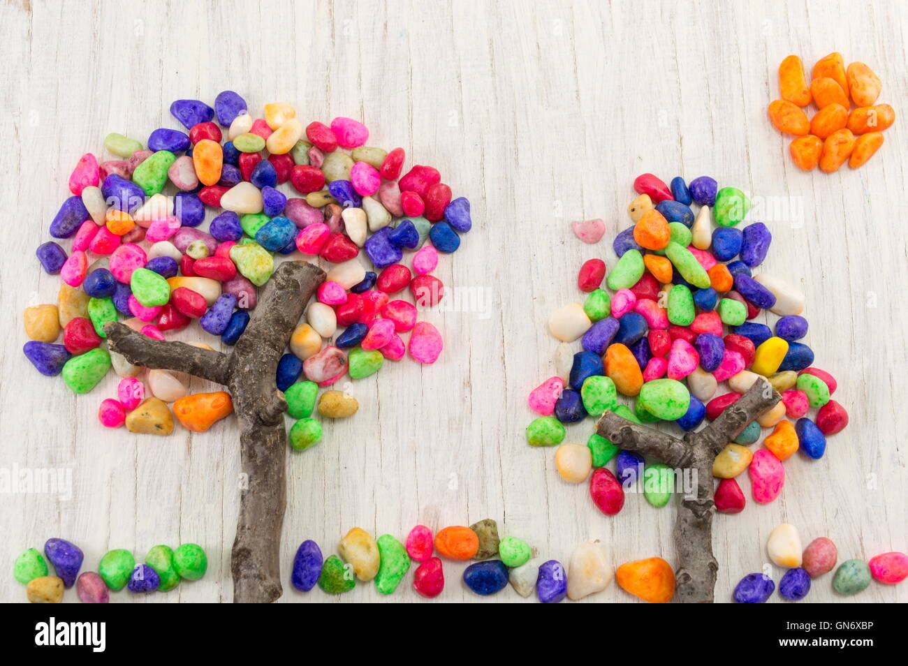 Rocce colorate formando una forma ad albero sul tavolo di legno Foto Stock