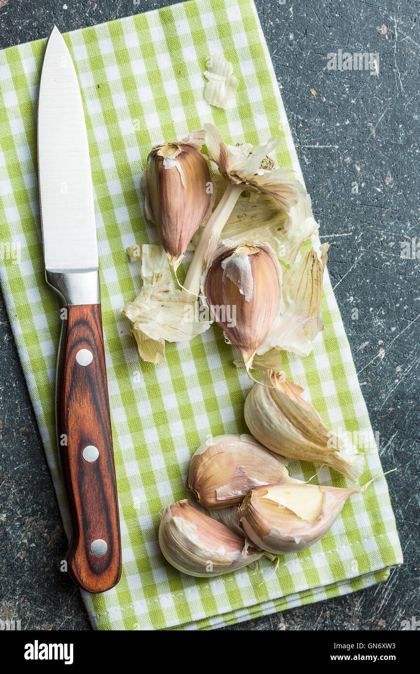 L'aglio fresco con il coltello sul tavolo da cucina. Foto Stock