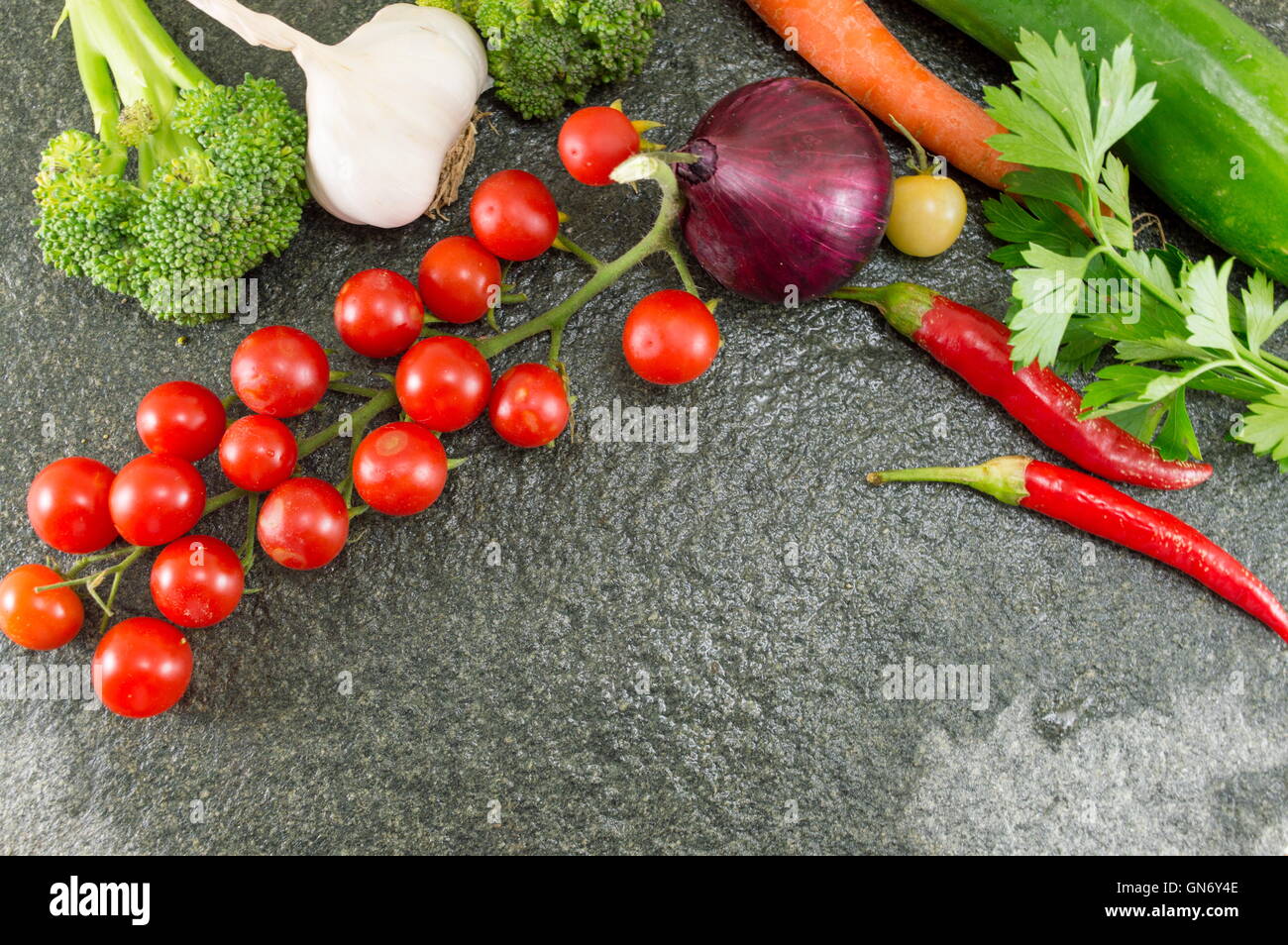 Pomodoro crudo e pepe rosso su sfondo di pietra Foto Stock