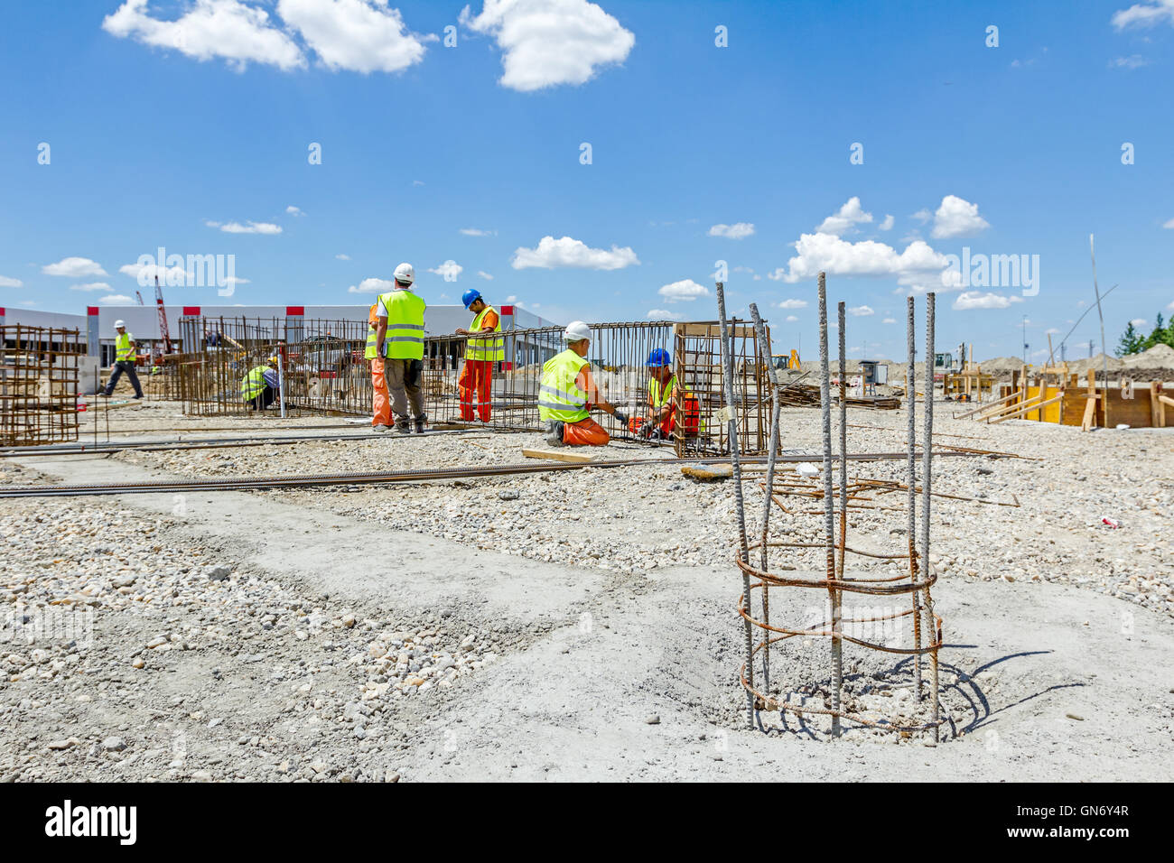 I lavoratori sono la legatura rebar per effettuare un nuovo basamento costruito il telaio. Il legame del telaio in calcestruzzo Foto Stock