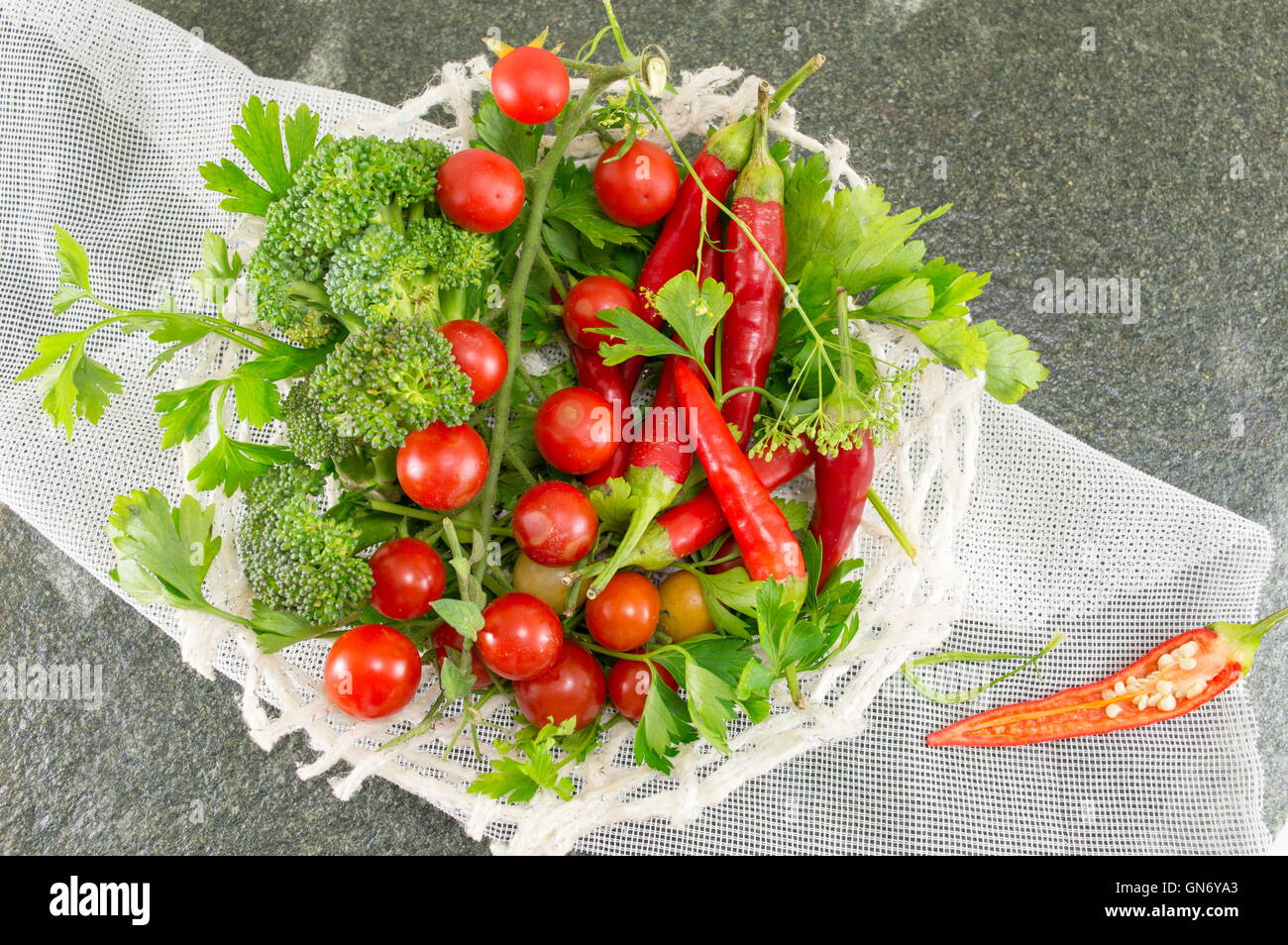 Pomodoro crudo e pepe rosso su sfondo di pietra Foto Stock