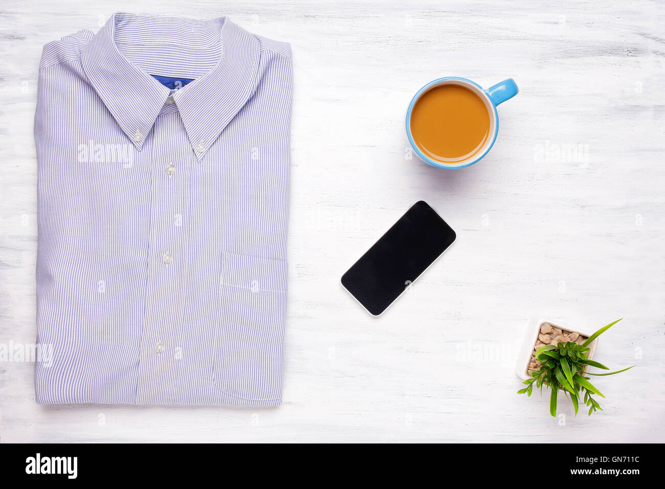 Vista dall'alto di imprenditore articoli su bianco tavolo in legno con smartphone con copyspace. Business e concetto di stile di vita. Foto Stock