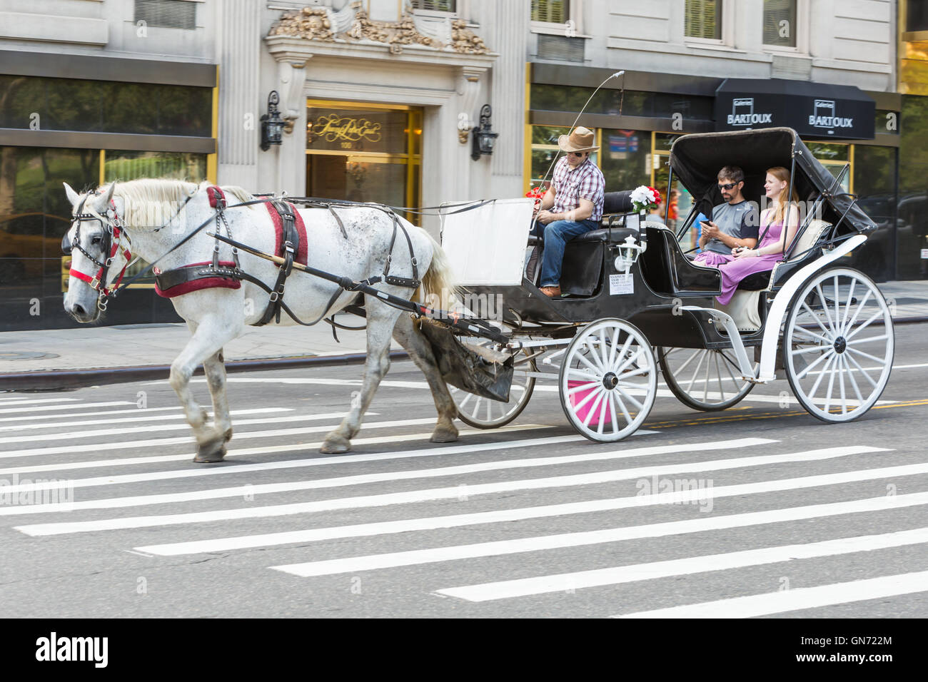 Un giovane prende un giro in carrozza nella città di New York. Foto Stock