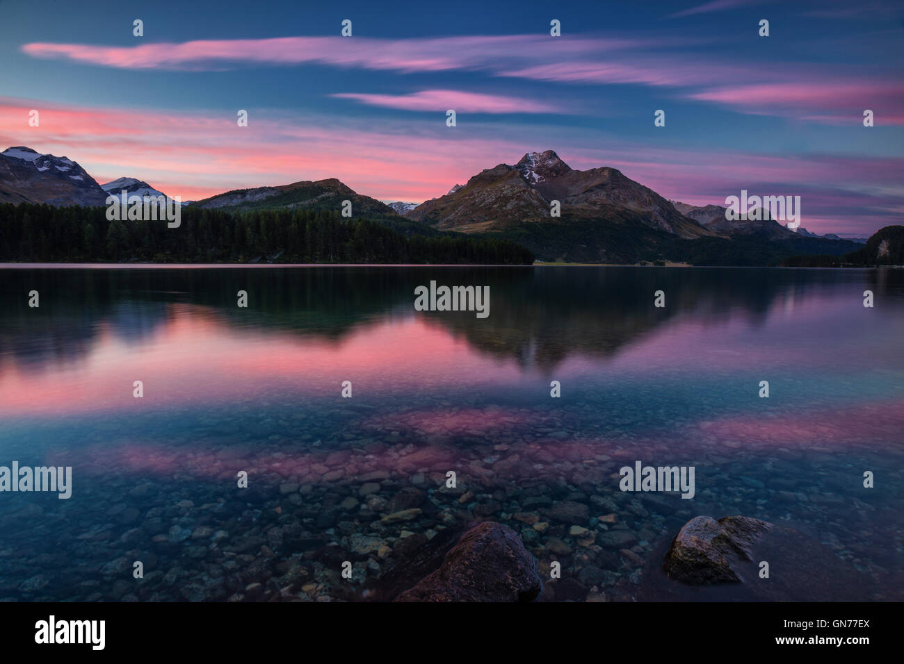 Cielo rosa all'alba illumina le vette riflesse nel lago di Sils Engadina Canton Grigioni Svizzera Europa Foto Stock