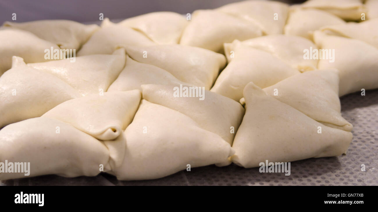 Impasto crudo su vassoi prima della cottura in un panificio industriale Foto Stock