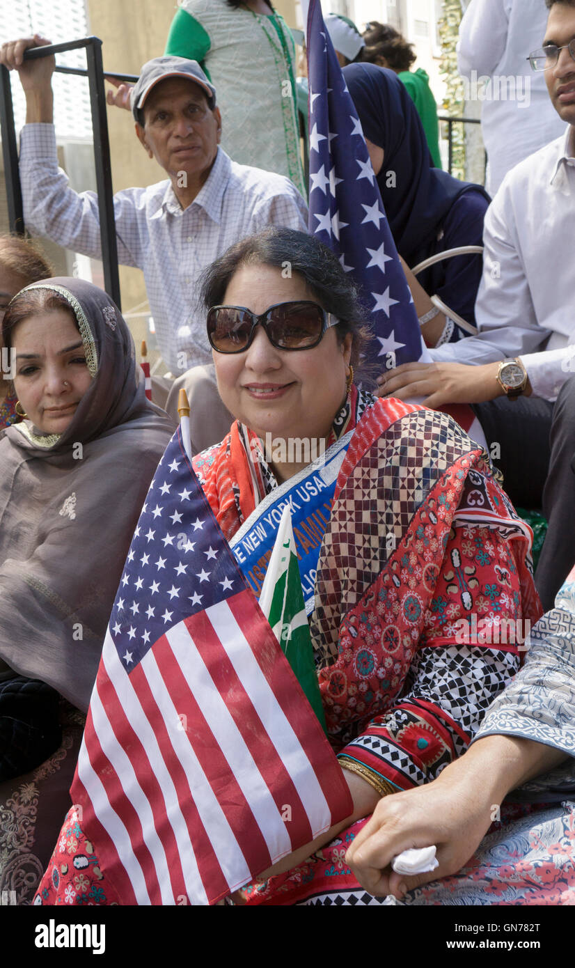 Una donna pakistana con una bandiera americana in un galleggiante a 2016 Pakistan parata del giorno nella città di New York Foto Stock