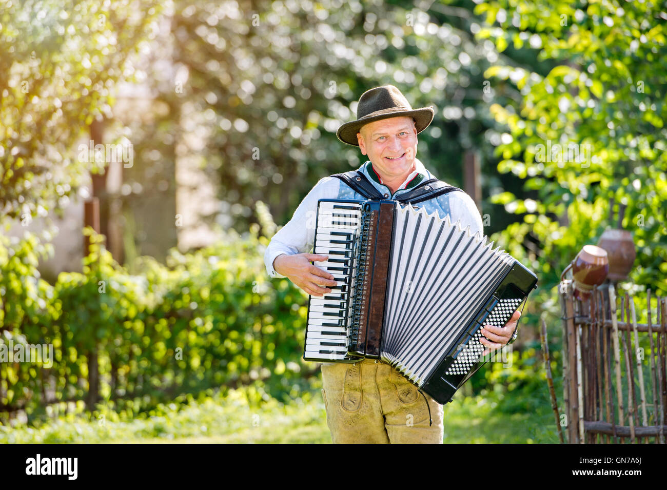 Uomo in tradizionali abiti bavarese suonando la fisarmonica Foto Stock