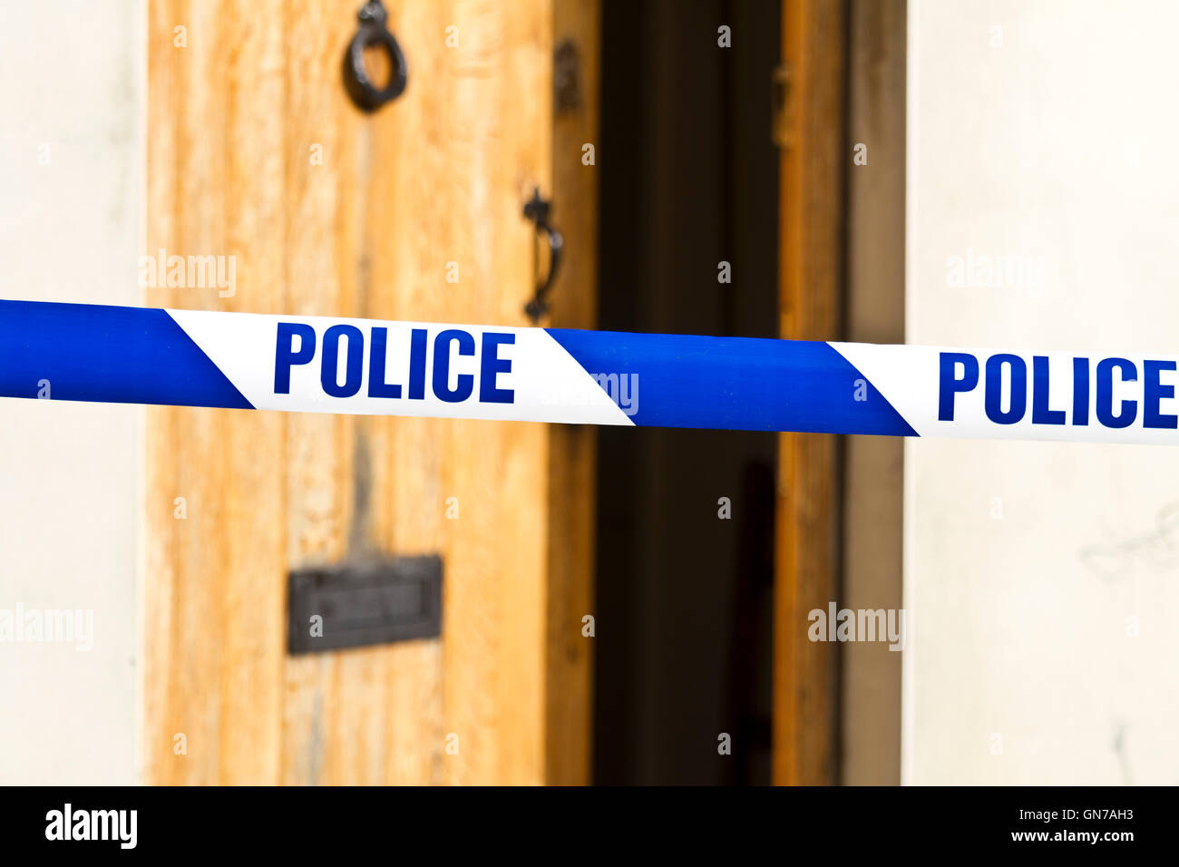 Polizia infilate su nastro attraverso una porta anteriore aperta con profondità di campo Foto Stock