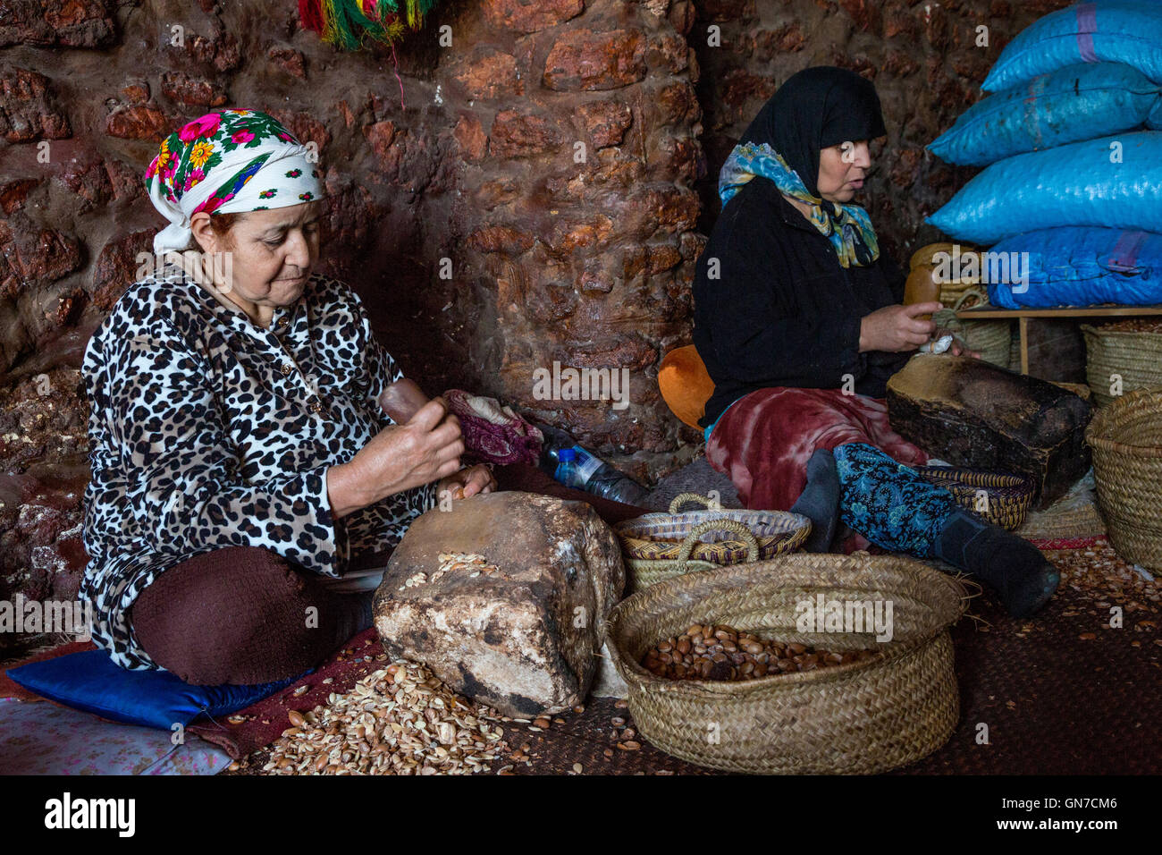 Il Marocco. Donne arabe Cracking dadi di Argan per la produzione di olio di Argan. Foto Stock