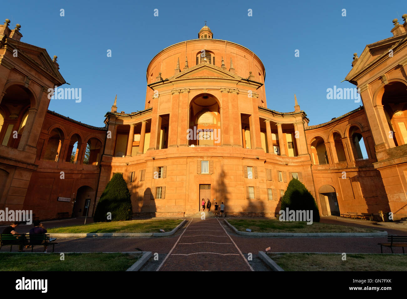 Bologna, Italia - 25 agosto 2016: turisti al tramonto di fronte alla facciata della Cattedrale cattolica di San Luca sul pendio di una collina Foto Stock