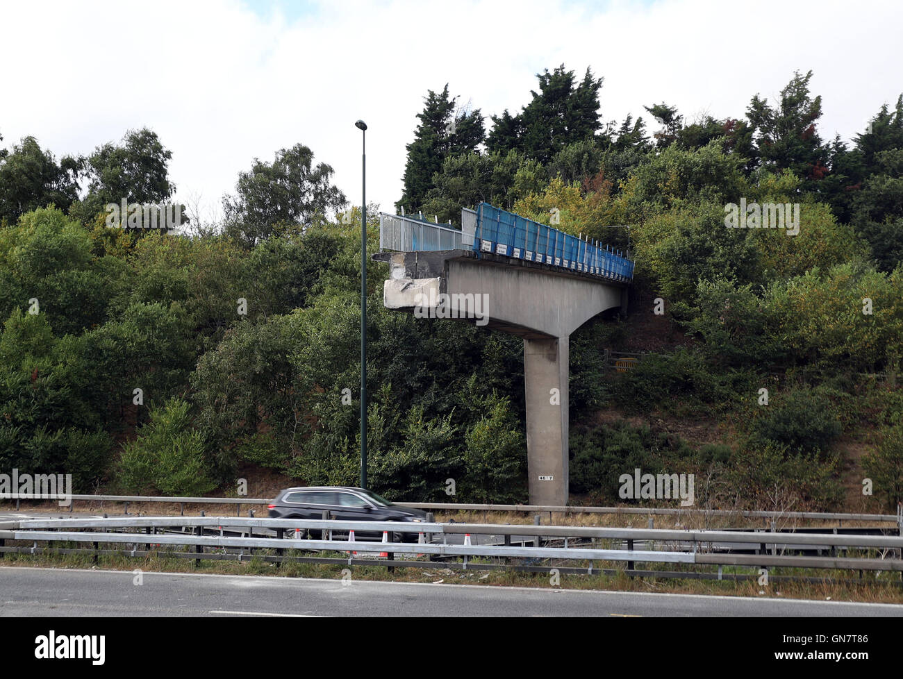 Il traffico sulla carreggiata est dell'autostrada M20 passano sotto la parte rimanente della passerella che è crollato dopo che ieri era stato colpito da un camion. Foto Stock