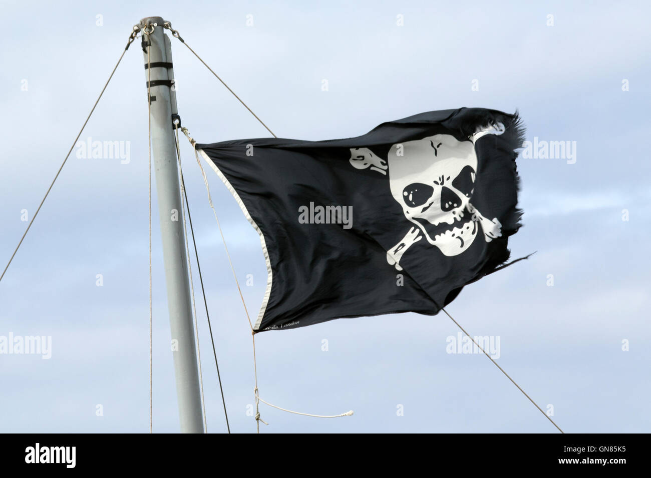 Skull & crossbones bandiera visualizzata sulla barca ormeggiata blakeney off in Norfolk Foto Stock