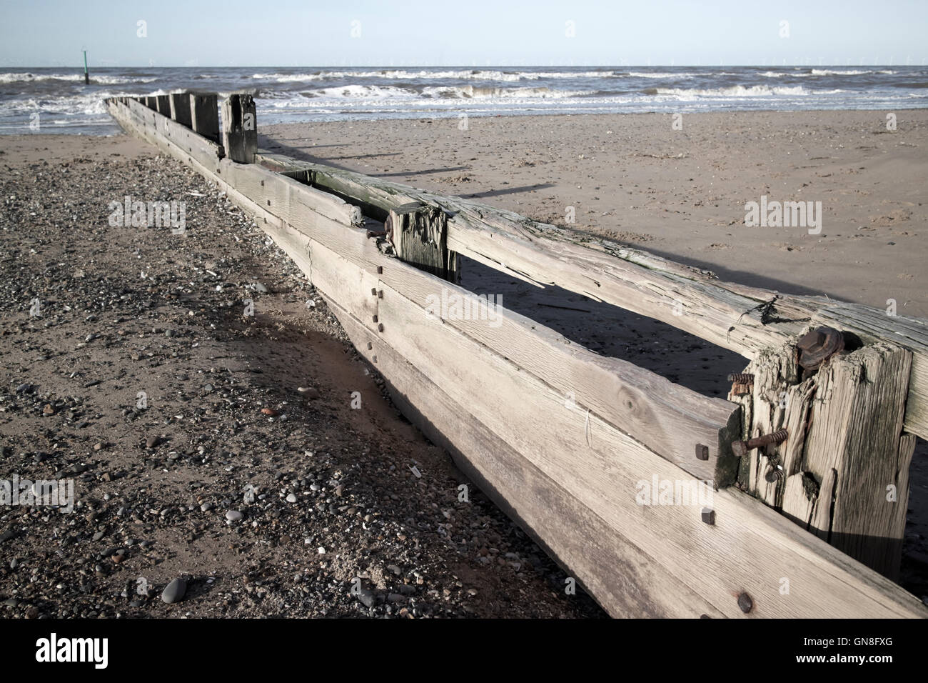 Groyne in legno le difese di mare sulla spiaggia di rhyl Galles del nord Foto Stock