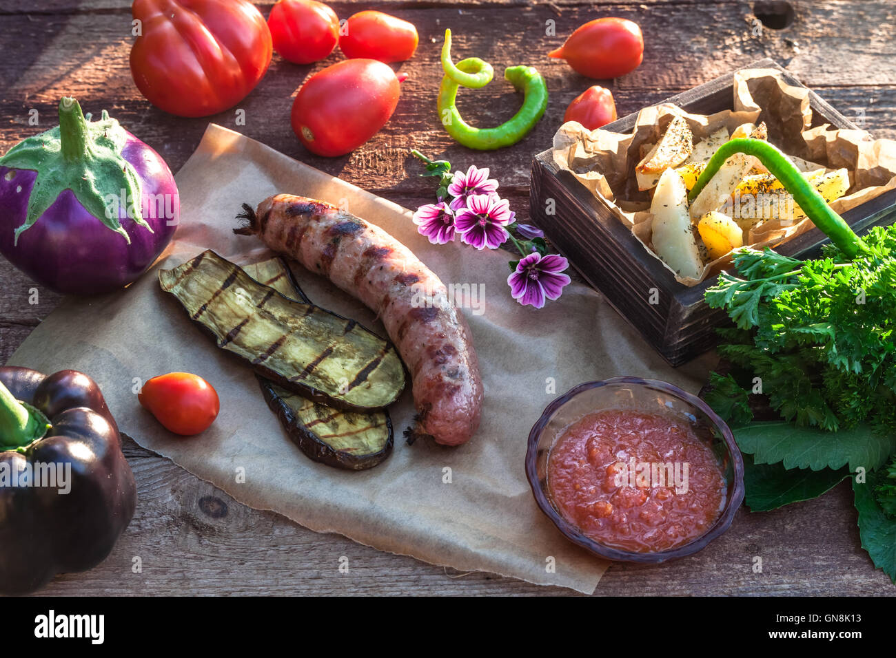 Salsicce alla griglia e verdura in stile rustico. Messa a fuoco selettiva Foto Stock