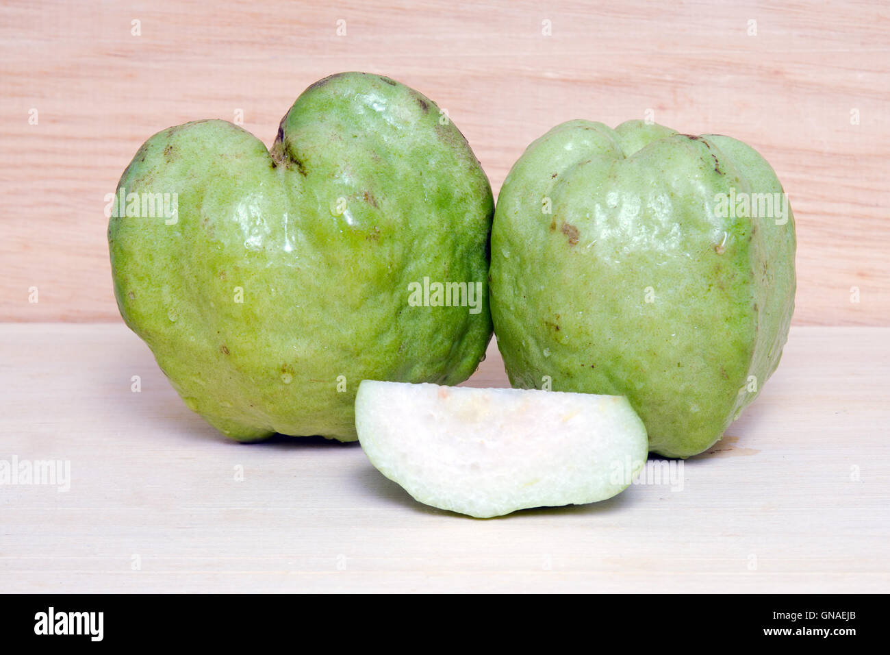 Frutto guava (chiamato anche come, Psidium guajava, limone guaiava, guayaba, Arawak guayabo, Subergine, comune di guava) isolato su legno Foto Stock
