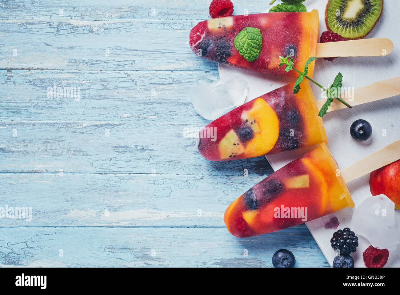 In casa delle bacche e frutta pop di ghiaccio su sfondo ciano vista superiore Foto Stock