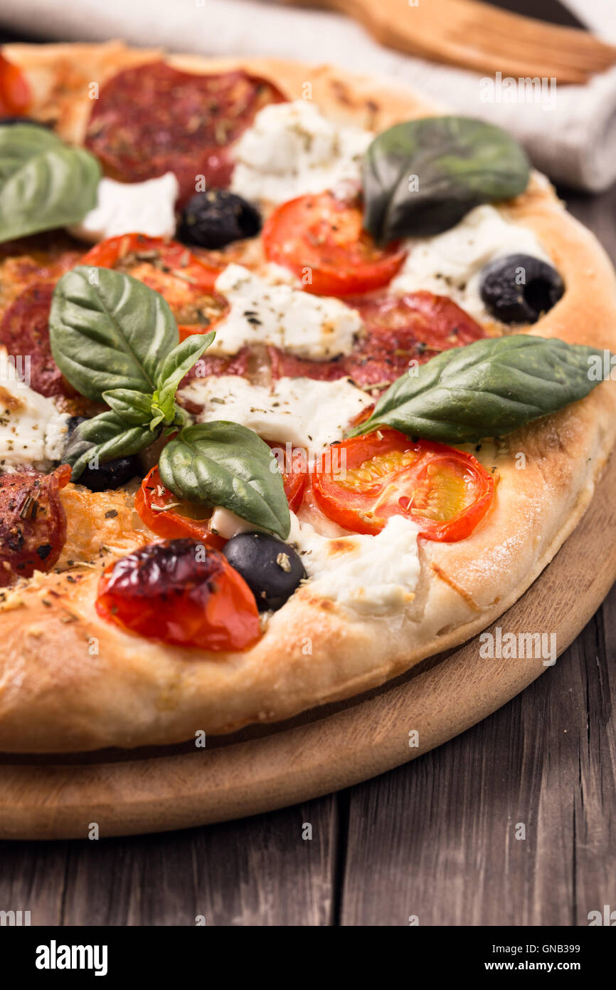 La pizza fatta in casa con salame e mozzarella tagliata Foto Stock