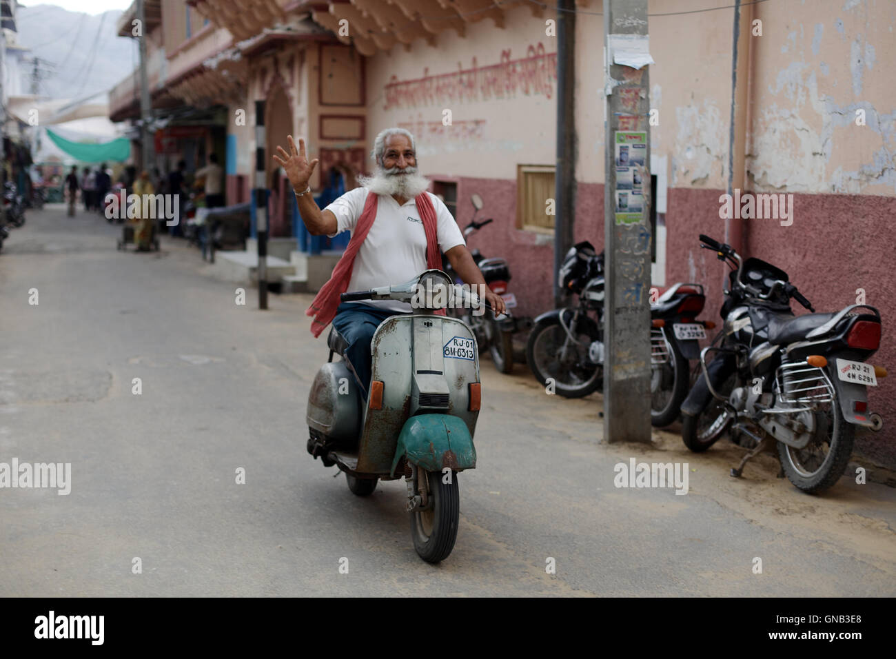 Un uomo felice alla guida della sua moto in Pushkar, Rajasthan, India. Foto Stock