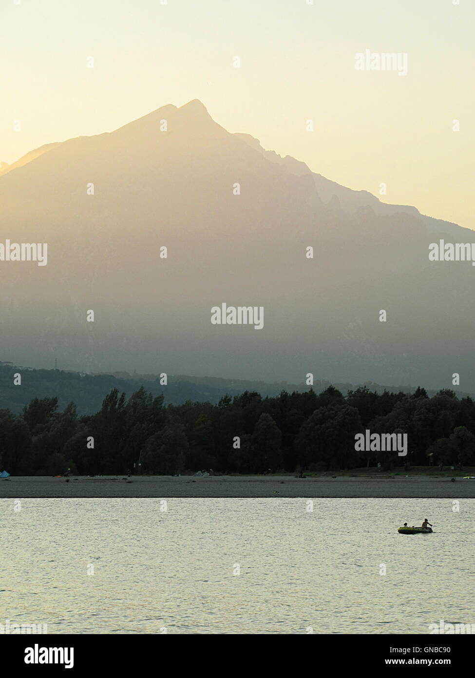 Full frame shot di sunny paesaggio con la montagna, lago, la foresta e la piccola barca Foto Stock