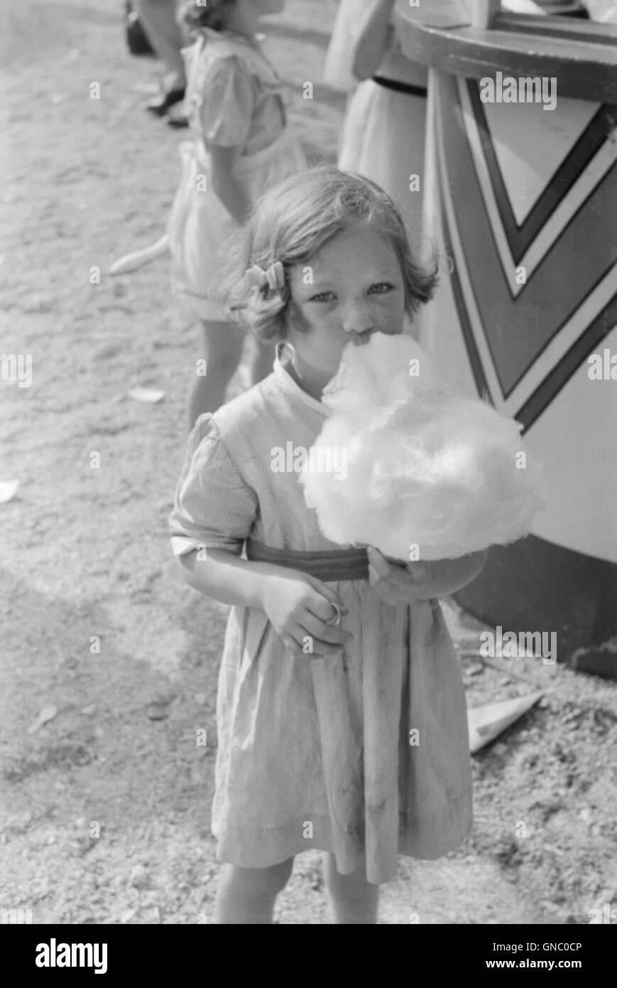 Ragazza giovane mangiando caramelle di cotone, cotone Carnevale, Memphis, Tennessee, Stati Uniti d'America, Marion Post Wolcott per la Farm Security Administration, Maggio 1940 Foto Stock