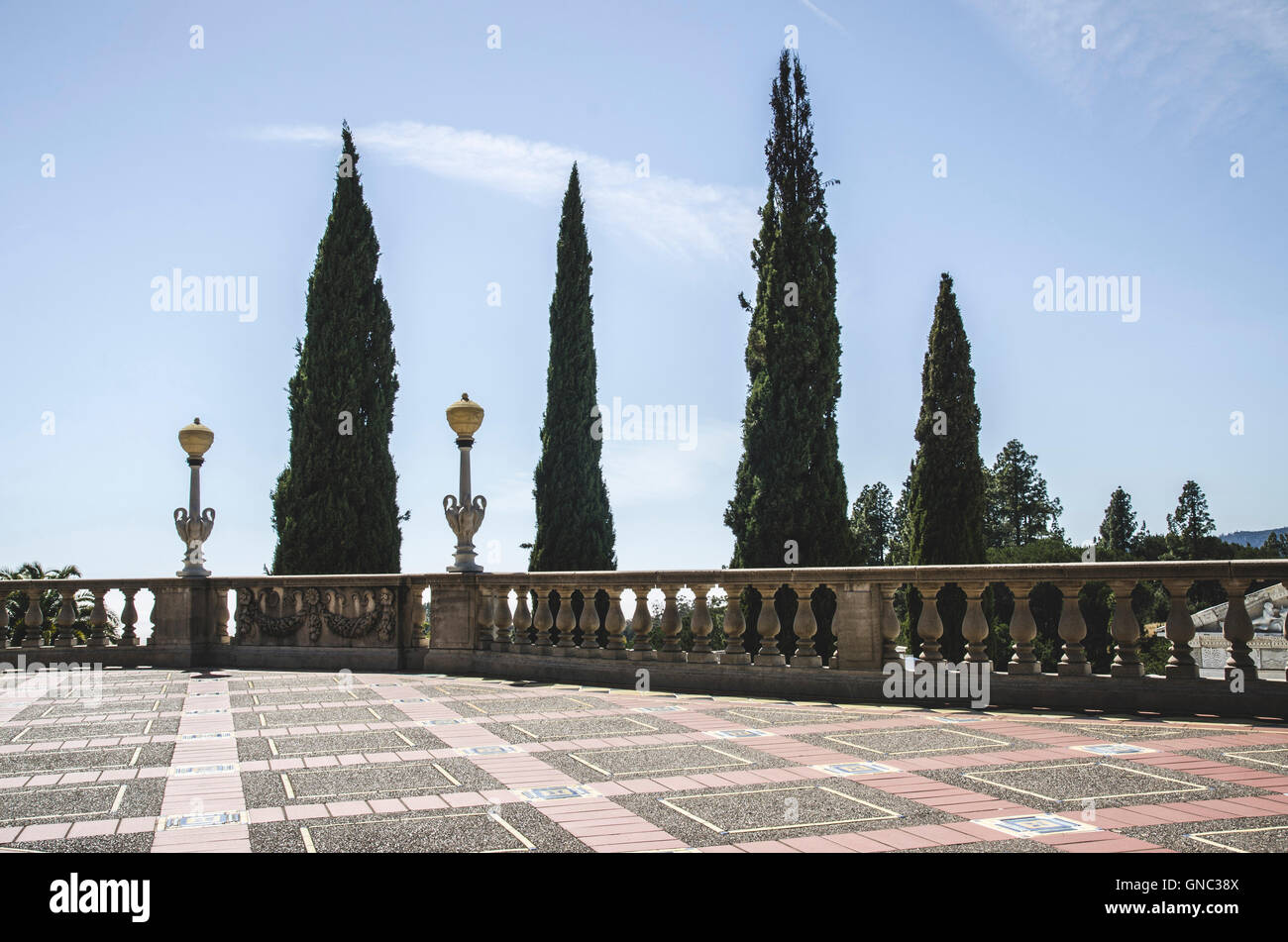 Terrazza e balaustra contro gli alberi alti, il Castello di Hearst, San Simeone, CALIFORNIA, STATI UNITI D'AMERICA Foto Stock