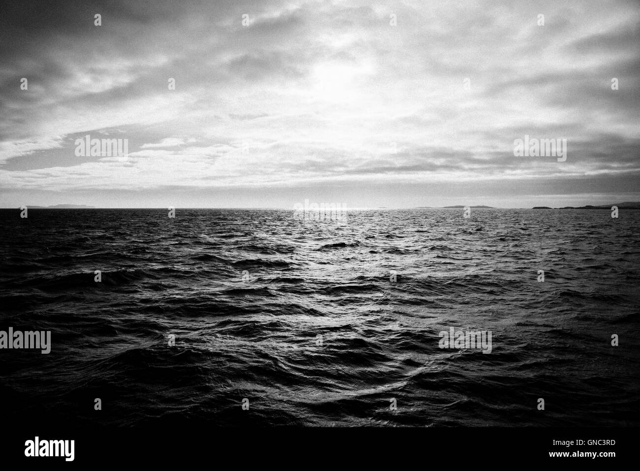 Seascape con barlume di luce del sole sull'acqua contro il cielo nuvoloso, Irlanda Foto Stock