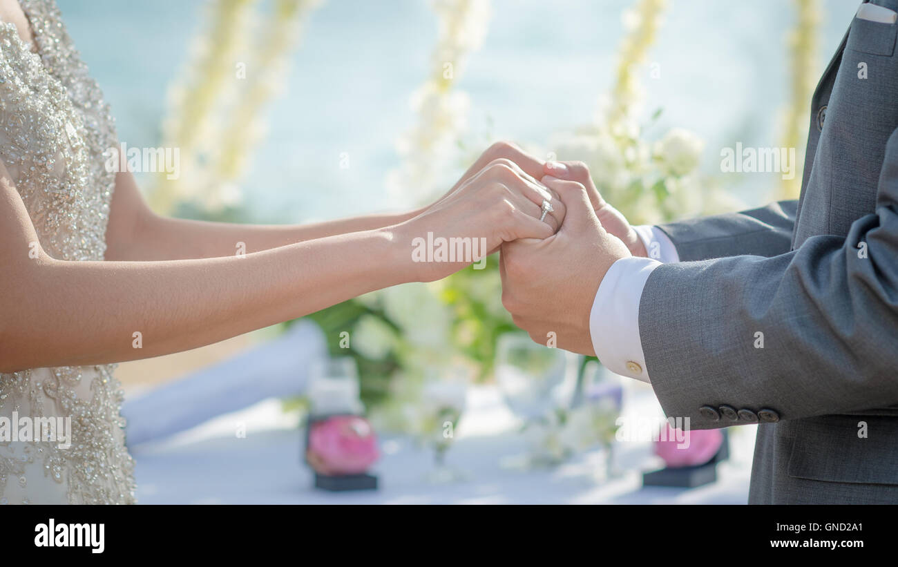 Uomo e donna tenendo le mani nella cerimonia di matrimonio. Mano nella mano. Foto Stock