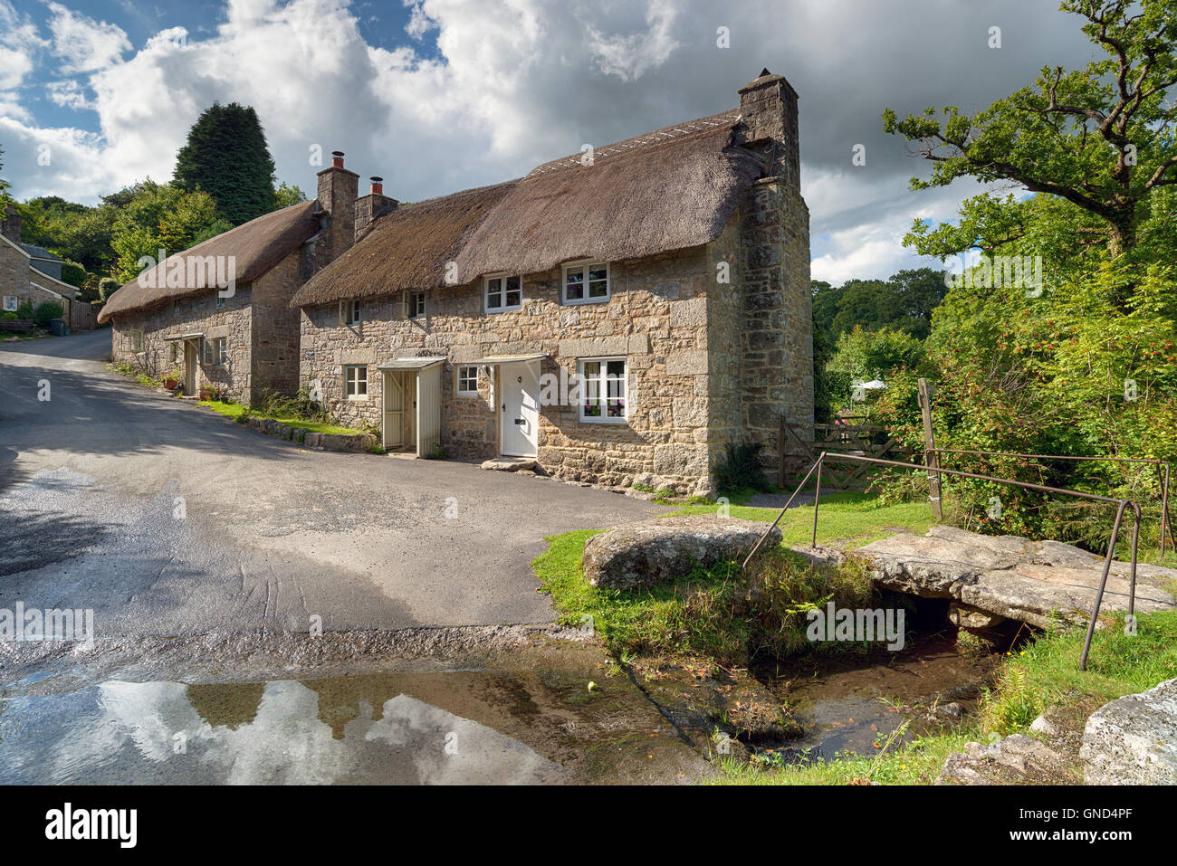 Splendido cottage con il tetto di paglia accanto a una Ford a Ponsworthy sul Parco Nazionale di Dartmoor in Devon Foto Stock