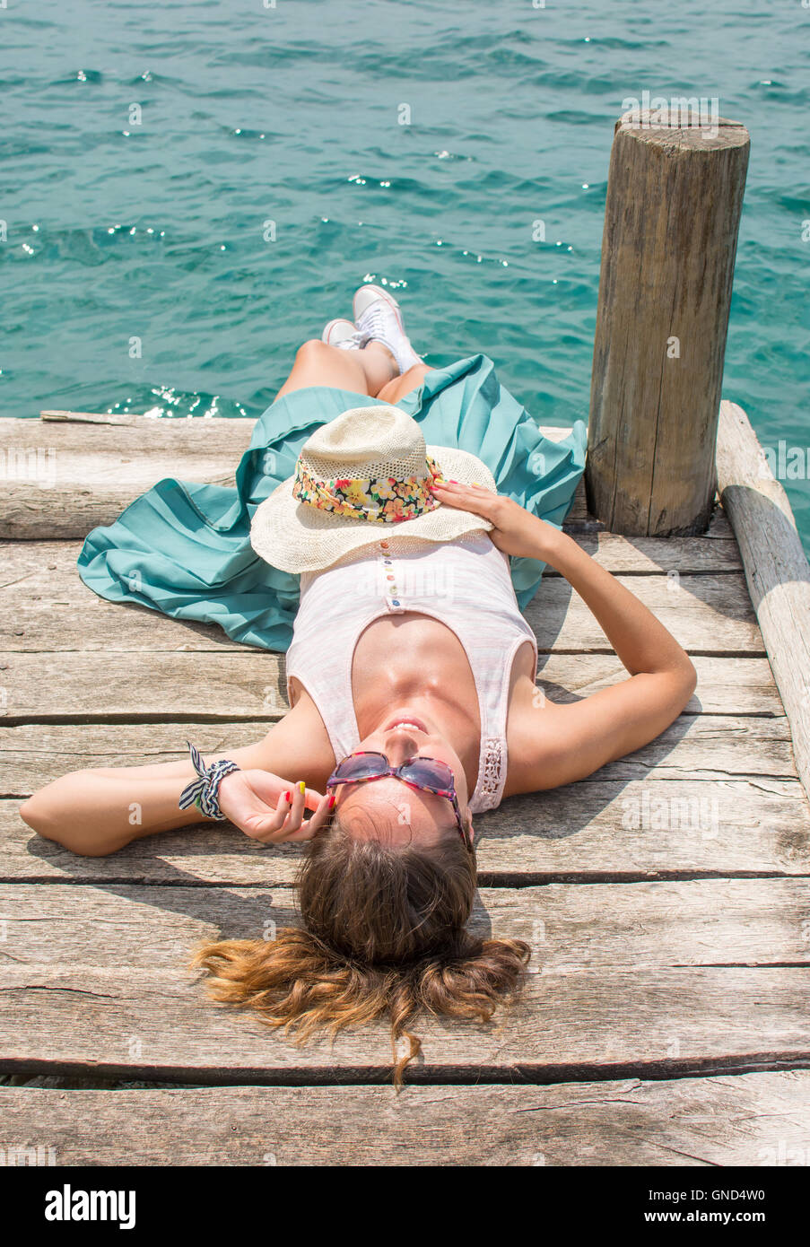 Moda giovane donna sdraiata su un dock Foto Stock
