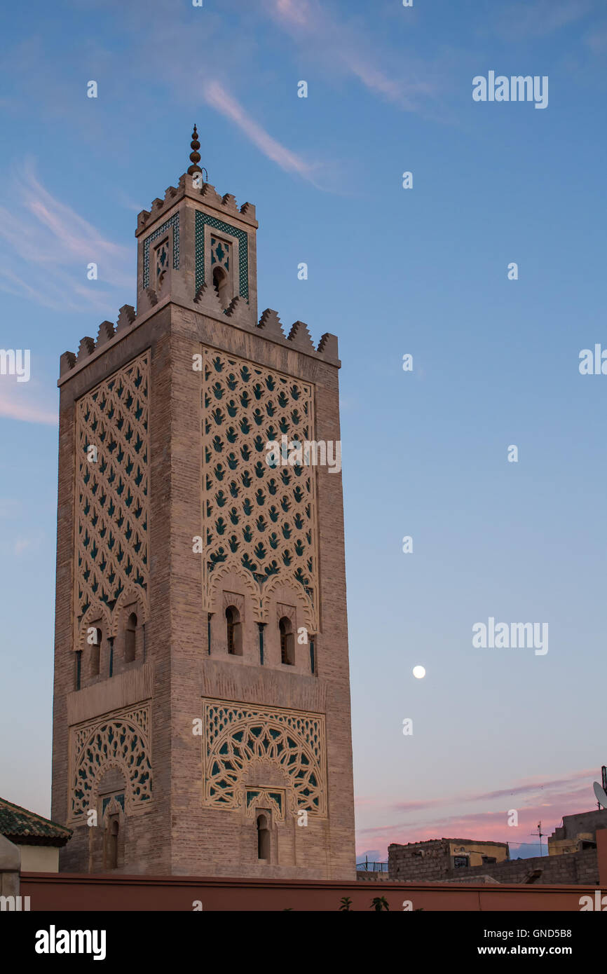 Minareto della Moschea, presso la piazza principale di Marrakesh, nel tempo di un tramonto, con ancora blu cielo con alcune nuvole. Foto Stock