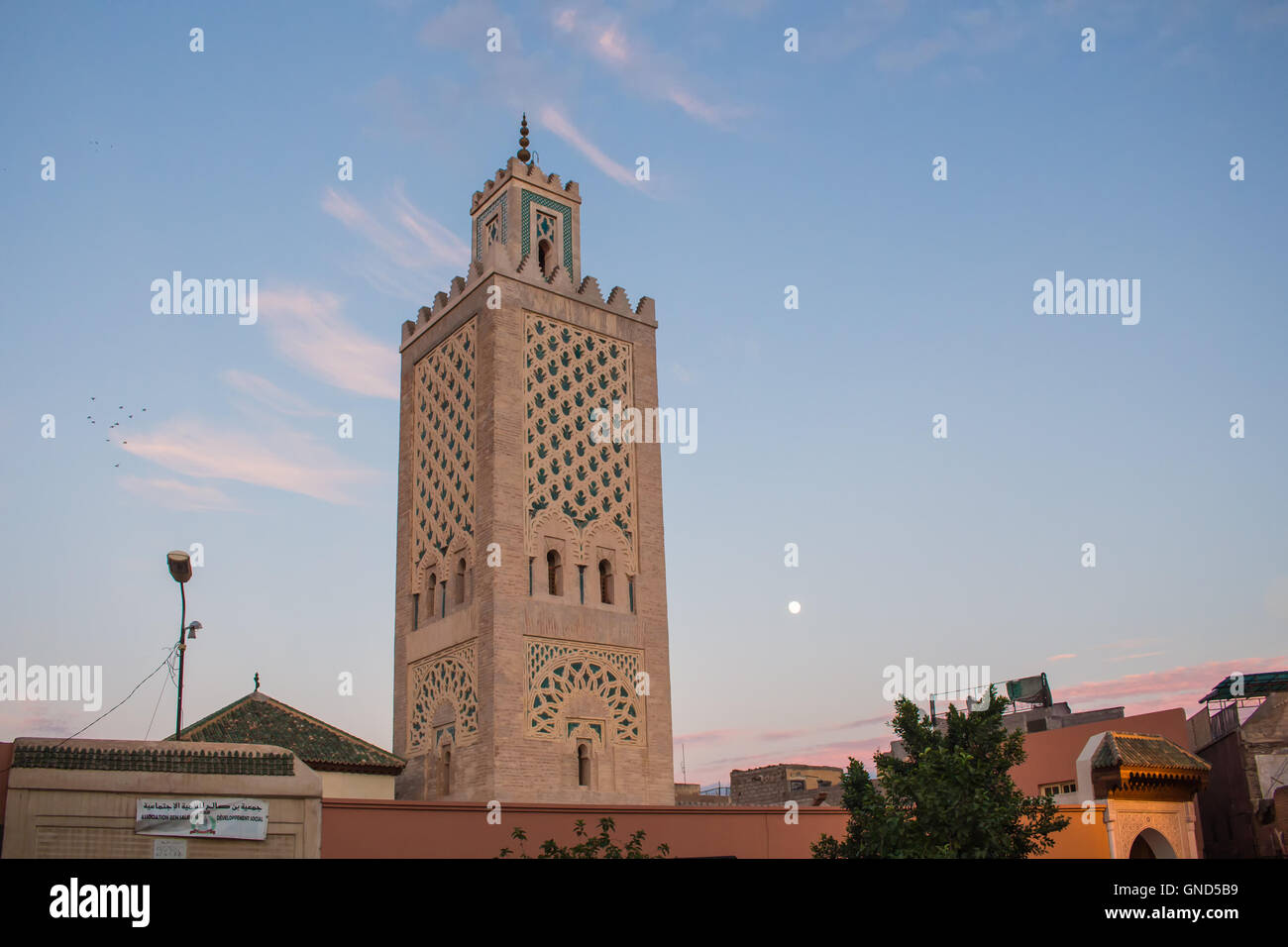 Minareto della Moschea, presso la piazza principale di Marrakesh, nel tempo di un tramonto, con ancora blu cielo con alcune nuvole. Foto Stock