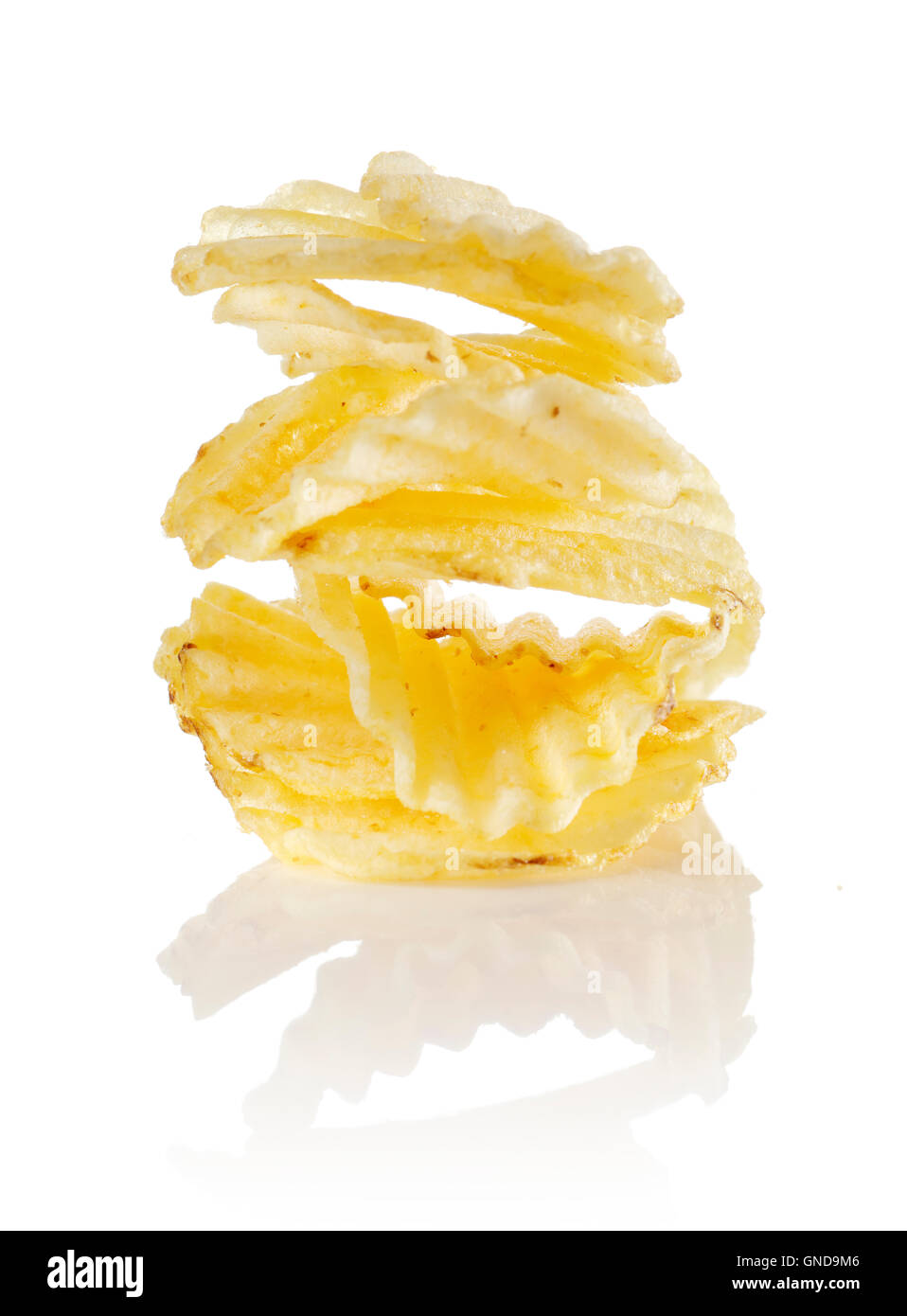 Non aromatizzato increspata potato chips impilati su un sfondo riflettente. Foto Stock