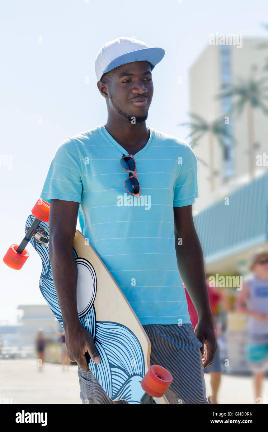 Giovane americano africano l uomo con il suo skateboard Foto Stock