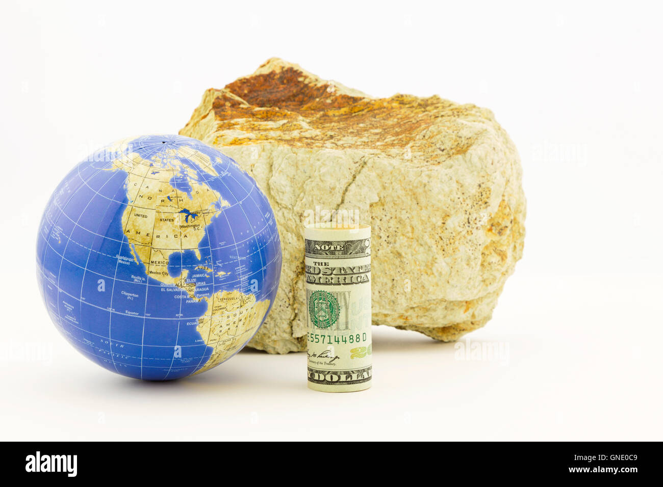 Moneta americana con globo di fronte salda roccia riflette le influenze globali delle politiche economiche. Foto Stock