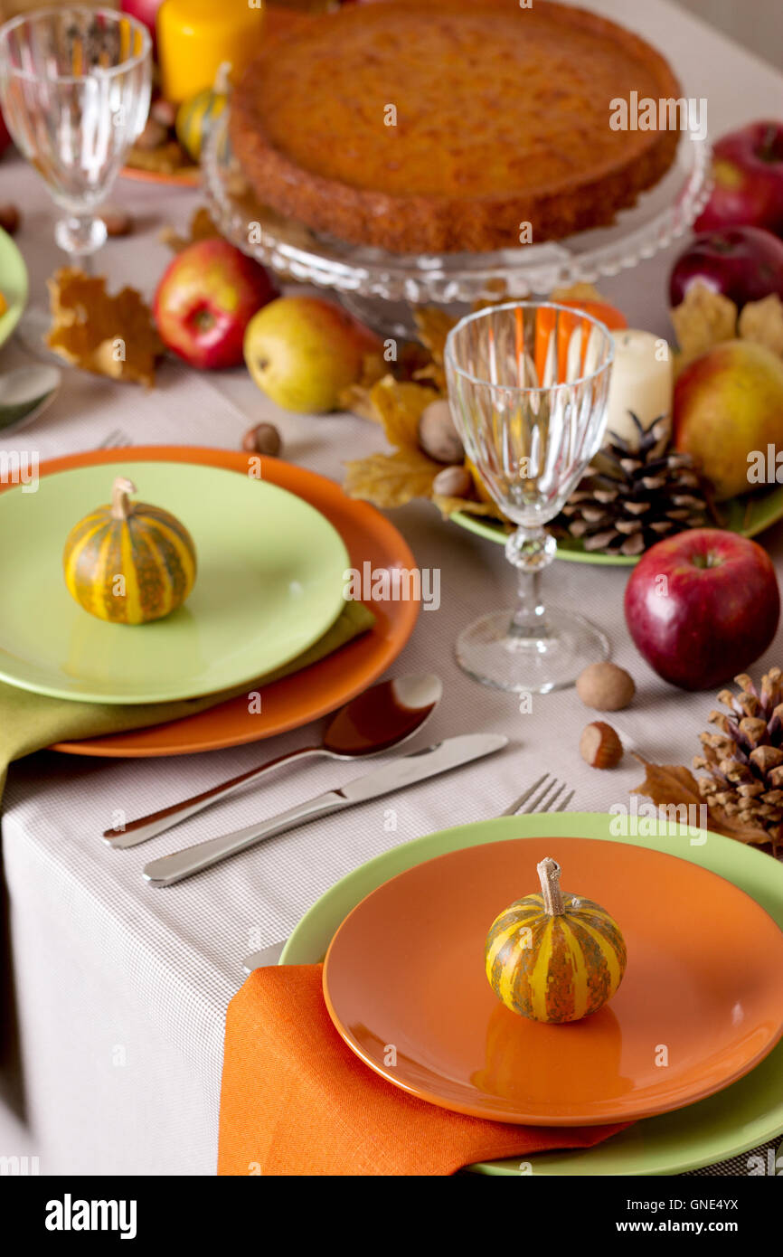 Cena di ringraziamento. Tabella stagionale impostazione con foglie di autunno, candele e zucche. Foto Stock