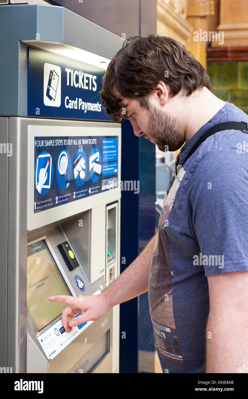 L'uomo comprare i biglietti del treno a una biglietteria automatica, la stazione di Nottingham, Inghilterra, Regno Unito Foto Stock