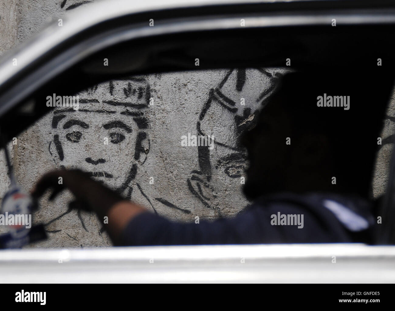 Sanaa, Yemen. Il 30 agosto, 2016. Un uomo yemenita rigidi passato un disegno di una vittima di sparizione forzata in una strada a Sanaa, Yemen, il 30 agosto 2016. Giornata internazionale delle vittime di sparizioni forzate è contrassegnata sul 30 agosto di ogni anno. © Hani Ali/Xinhua/Alamy Live News Foto Stock