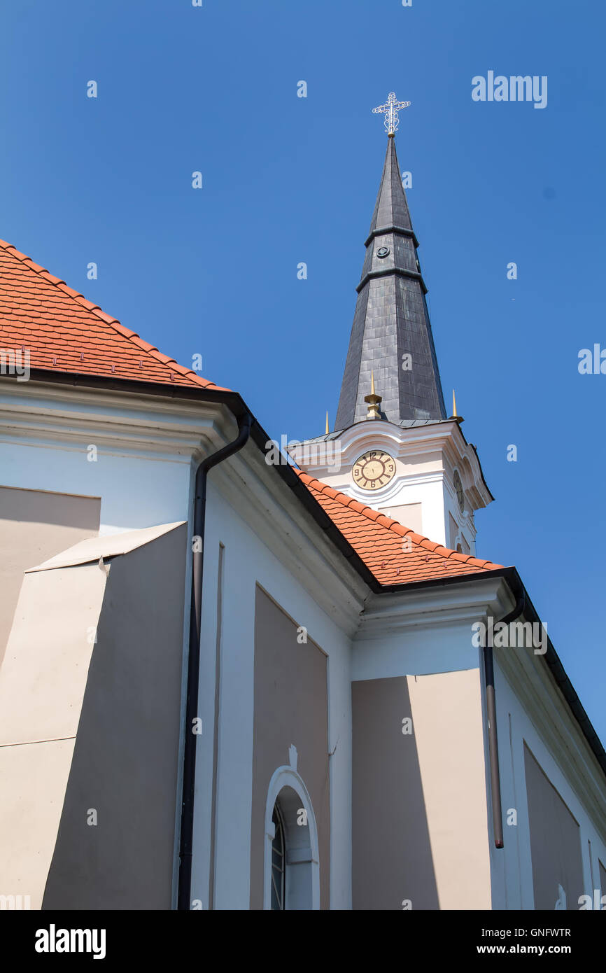 Dettagli dell'architettura di una piccola chiesa cattolica. Tower con una croce. Azzurro cielo. Tomasikovo, Slovacchia. Foto Stock