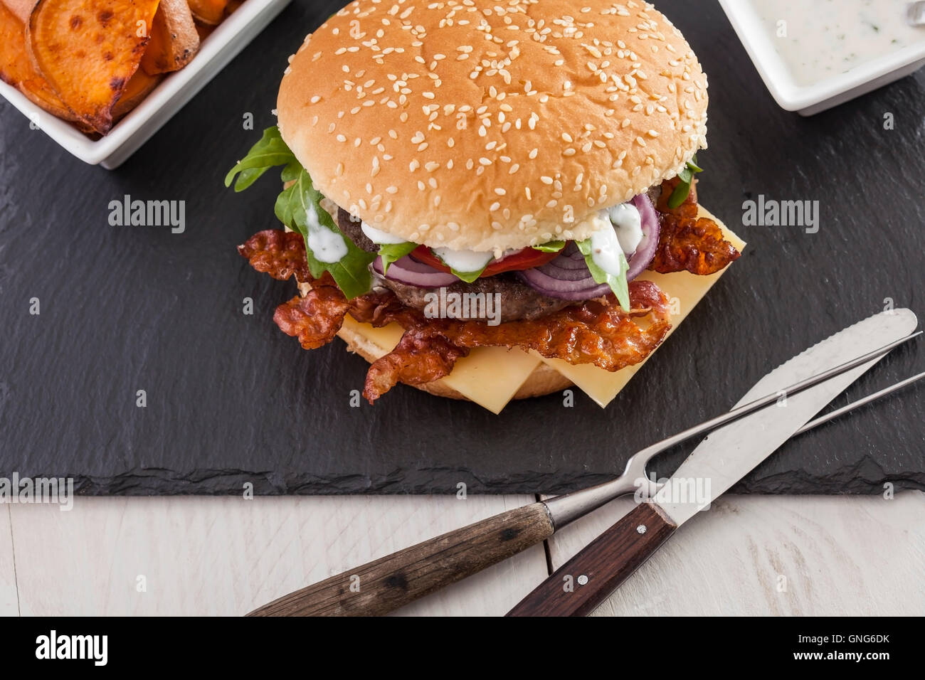 Gourmet home realizzati bacon cheeseburger su rustiche sfondi in legno Foto Stock